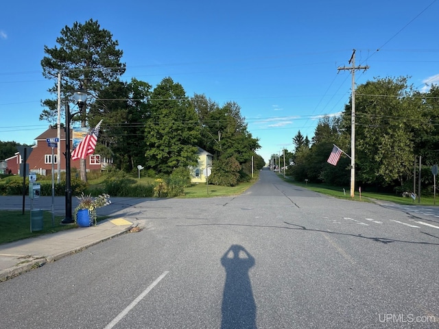 view of road featuring sidewalks, traffic signs, and curbs