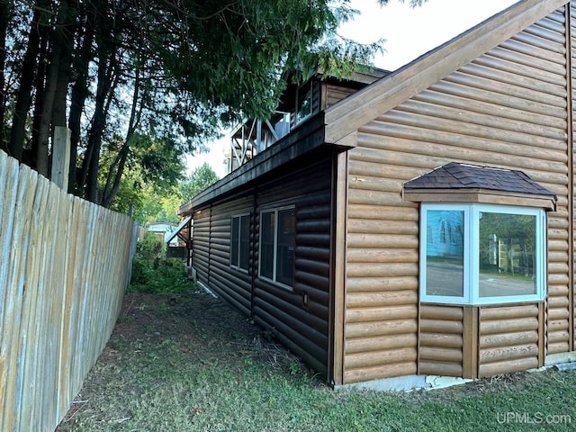 view of home's exterior with fence and faux log siding