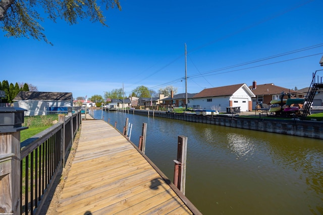 dock area with a water view, fence, and a residential view