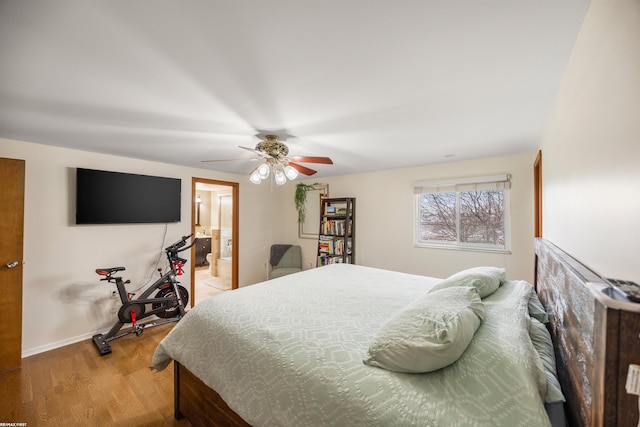 bedroom with light wood-style floors, a ceiling fan, baseboards, and ensuite bathroom