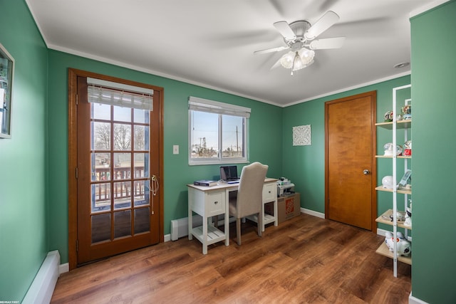 office space featuring baseboards, ceiling fan, a baseboard heating unit, and wood finished floors