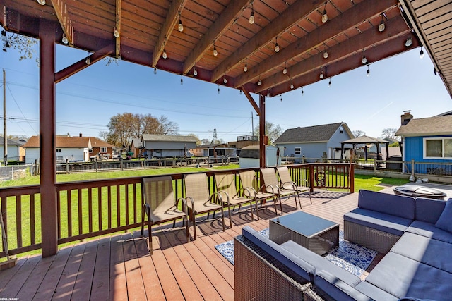 wooden terrace featuring an outdoor hangout area, fence, a yard, and a residential view