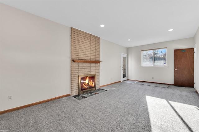 unfurnished living room with baseboards, recessed lighting, carpet, and a brick fireplace