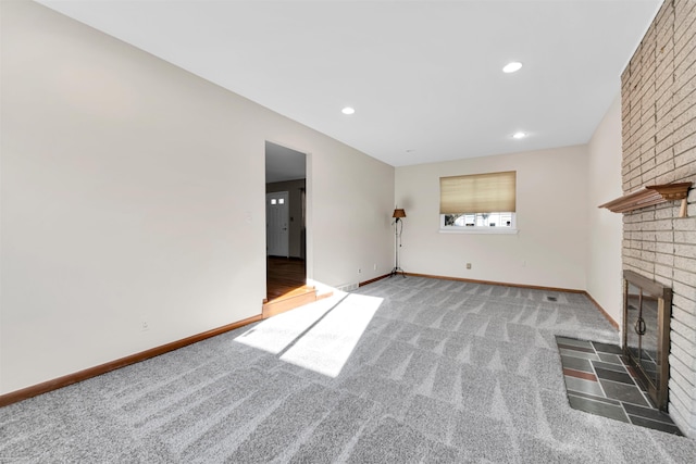 unfurnished living room featuring baseboards, carpet flooring, recessed lighting, and a fireplace
