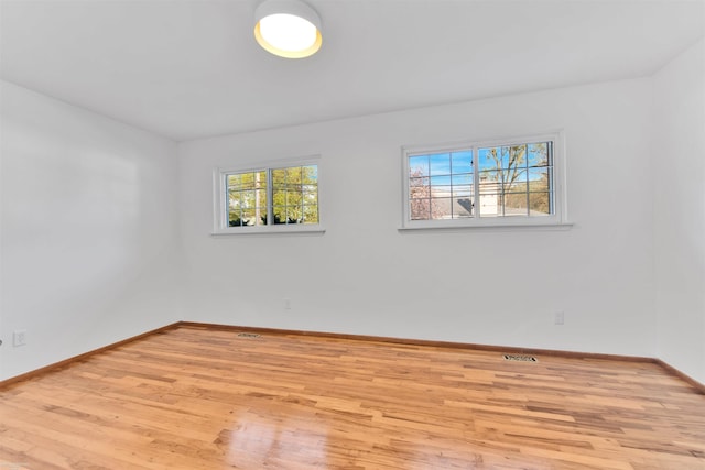 unfurnished room with baseboards and wood finished floors