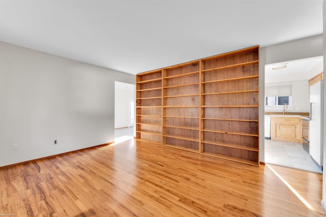 unfurnished room featuring a sink and light wood-type flooring