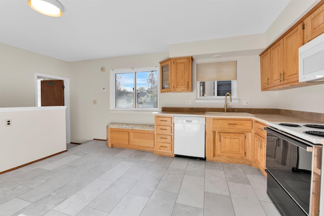 kitchen featuring white appliances, glass insert cabinets, and a sink