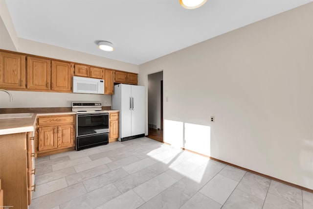 kitchen with white appliances, baseboards, a sink, and marble finish floor