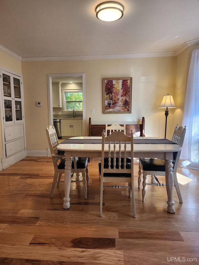 dining area with ornamental molding and wood finished floors