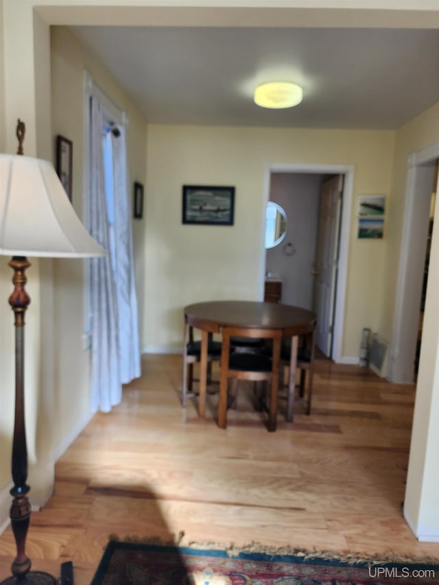 dining area featuring baseboards and light wood finished floors