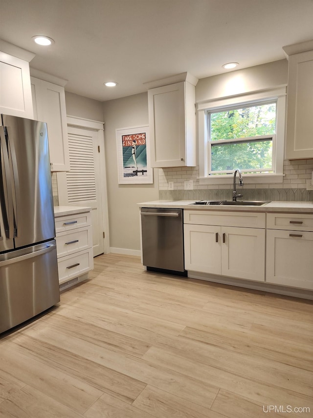kitchen featuring baseboards, a sink, tasteful backsplash, and stainless steel appliances