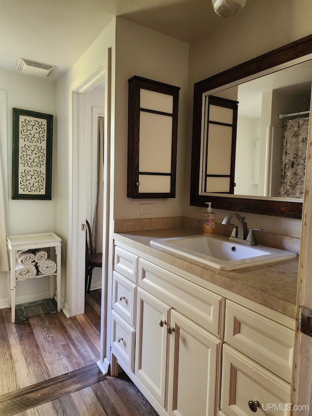 full bathroom featuring vanity, wood finished floors, and visible vents