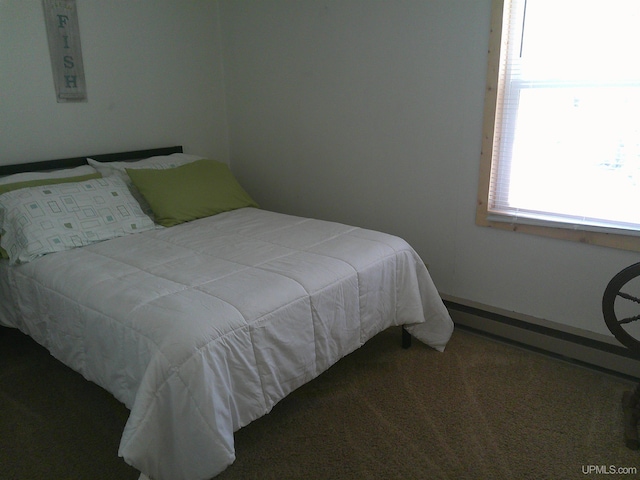 carpeted bedroom featuring a baseboard heating unit