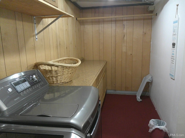 clothes washing area featuring wooden walls, laundry area, and washer / dryer