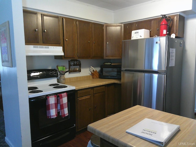 kitchen with electric range, dark brown cabinetry, black microwave, freestanding refrigerator, and under cabinet range hood