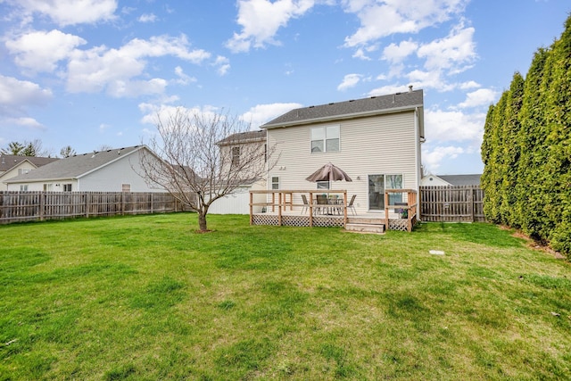 rear view of property with a fenced backyard, a yard, and a deck