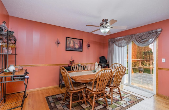 dining space with a ceiling fan, baseboards, and wood finished floors