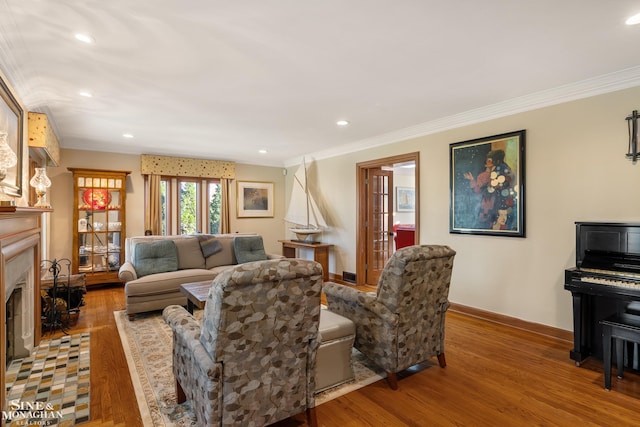 living area featuring baseboards, ornamental molding, and wood finished floors