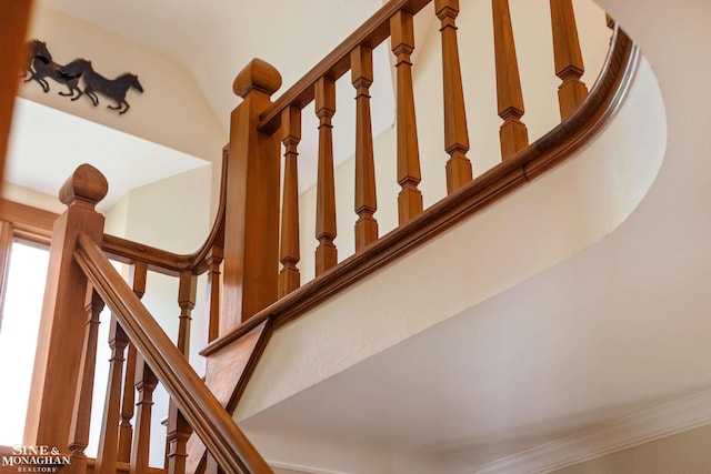 stairs featuring crown molding and a towering ceiling