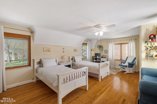 bedroom with vaulted ceiling, baseboards, a ceiling fan, and light wood-style flooring