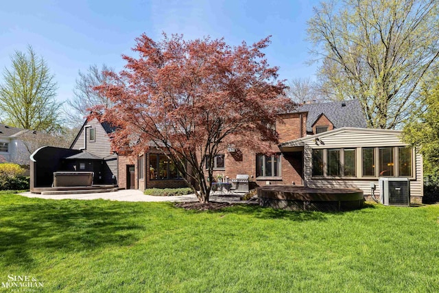back of house with a lawn, central air condition unit, a sunroom, and a patio