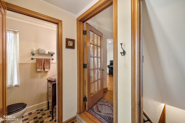 corridor with baseboards, wainscoting, and ornamental molding