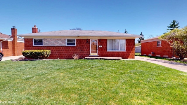 view of front of home featuring brick siding, a chimney, and a front lawn