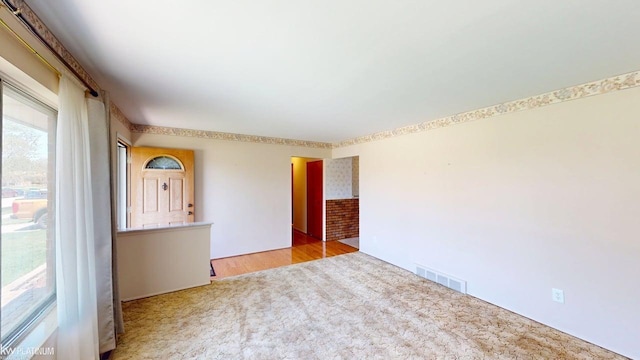 unfurnished room with visible vents and carpet