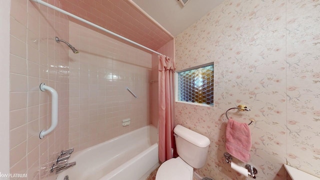 bathroom featuring wallpapered walls, toilet, and shower / tub combo