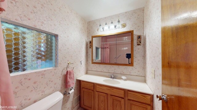 full bath with vanity, toilet, and wallpapered walls