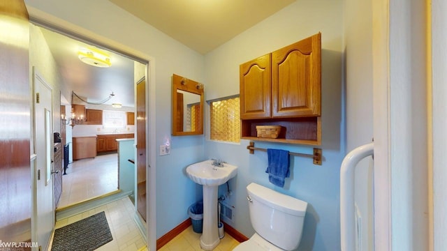 bathroom with toilet, baseboards, and ensuite bath