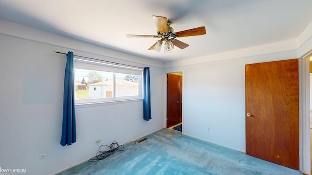 unfurnished room with carpet floors, a ceiling fan, and visible vents