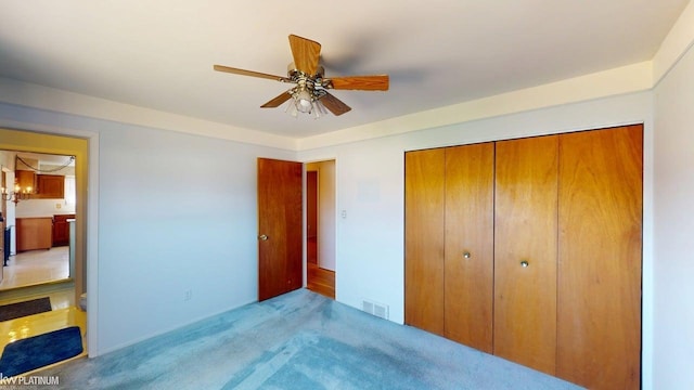 unfurnished bedroom with a ceiling fan, light colored carpet, visible vents, and a closet