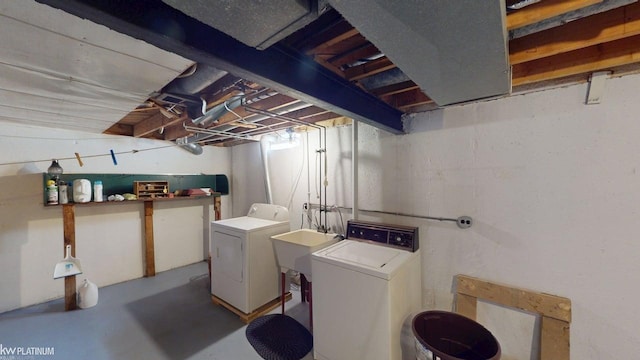 washroom with a sink, laundry area, and washer and clothes dryer