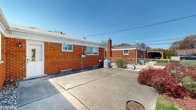 back of house with brick siding, fence, and a patio area