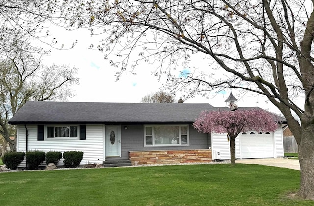 ranch-style home with roof with shingles, a front yard, a garage, concrete driveway, and entry steps