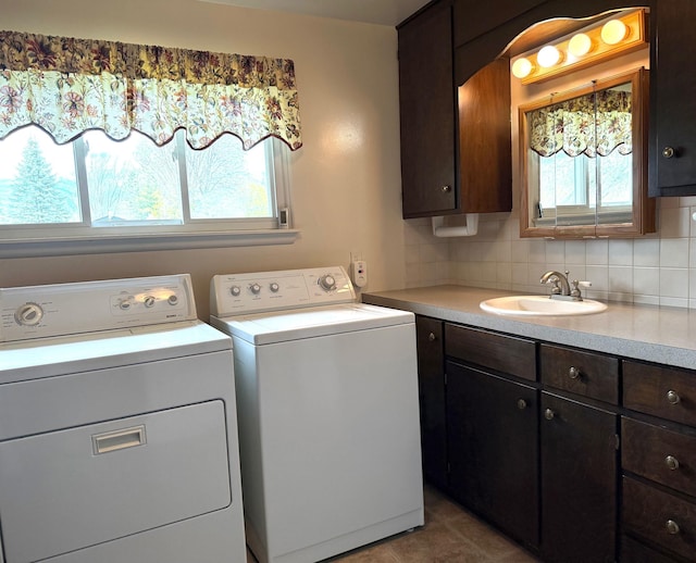 clothes washing area featuring washer and clothes dryer, a sink, and cabinet space
