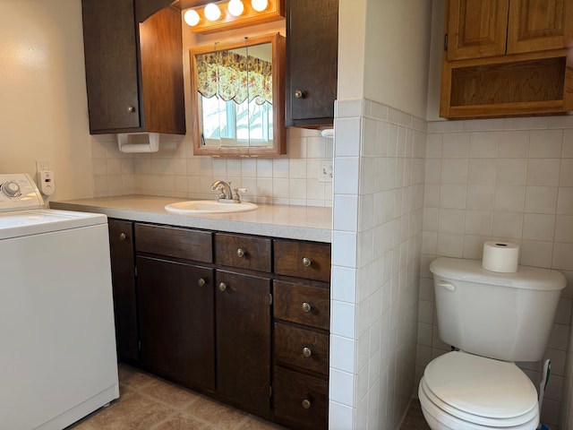 bathroom featuring toilet, washer / dryer, tasteful backsplash, and vanity