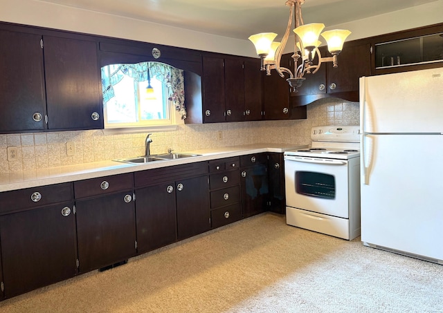 kitchen featuring a sink, light countertops, white appliances, and a chandelier