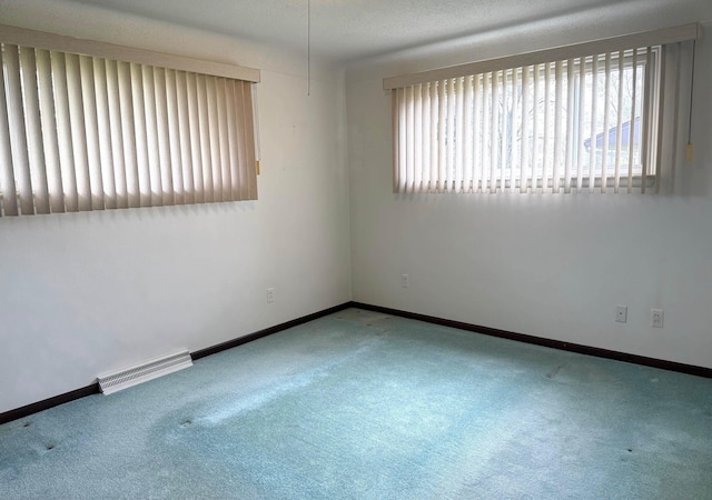 unfurnished room featuring carpet floors, baseboards, and visible vents