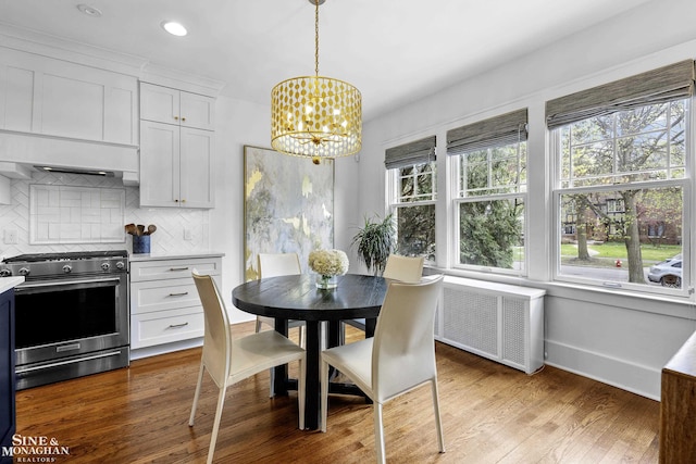 dining room featuring an inviting chandelier, baseboards, wood finished floors, and a wealth of natural light