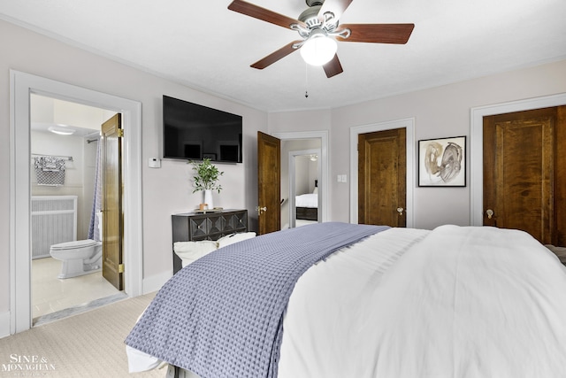 bedroom featuring a ceiling fan, radiator, and ensuite bath