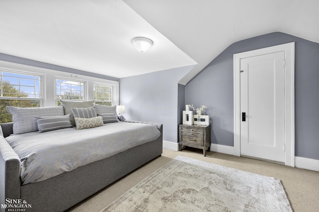 carpeted bedroom featuring baseboards and vaulted ceiling