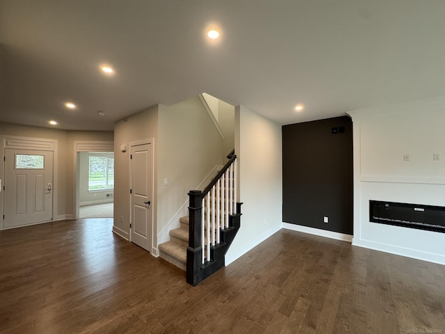 interior space featuring baseboards, stairway, recessed lighting, and dark wood-type flooring
