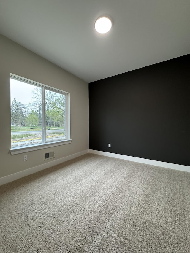 unfurnished room featuring visible vents, baseboards, and carpet floors