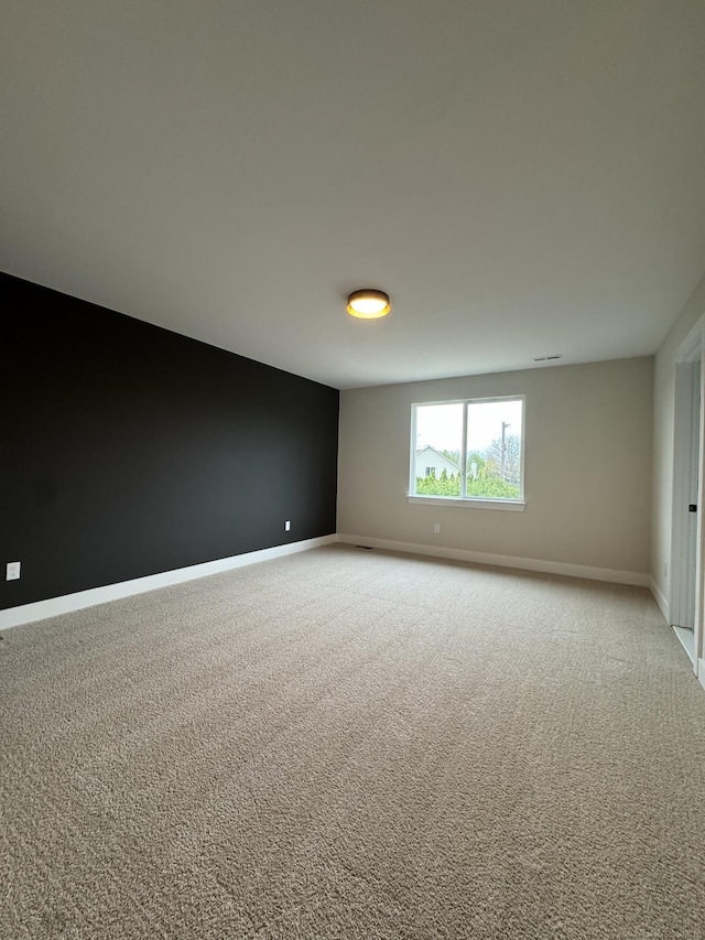 carpeted empty room featuring baseboards