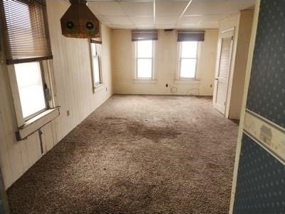 unfurnished room featuring carpet flooring and wallpapered walls