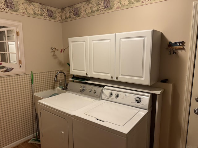 clothes washing area featuring cabinet space, tile walls, wainscoting, and washing machine and clothes dryer