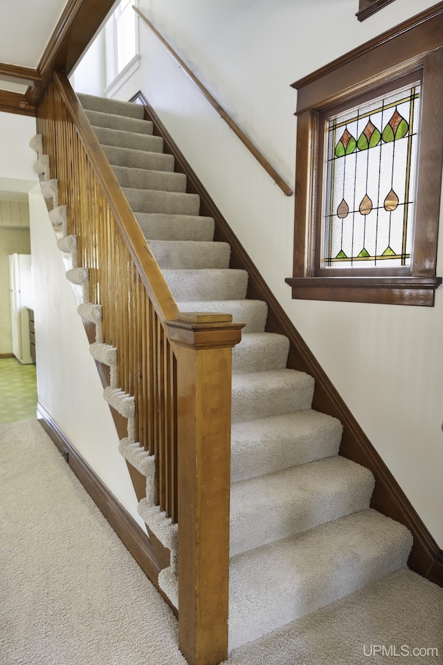 staircase with baseboards and carpet