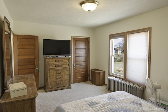 bedroom featuring radiator and light colored carpet